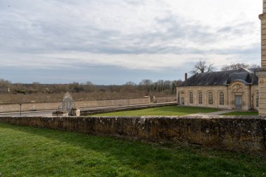 Ziyaretçiler La Roche-Guyon 'un huzurlu topraklarında dolaşır, doğanın uyumunu ve ilkbahar güneşinin erken saatlerindeki tarihi yapıları tecrübe ederler..
