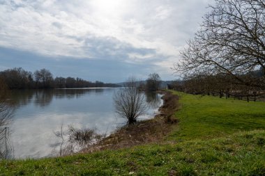 Sakin sular öğleden sonra gökyüzünün yumuşak ışığını yansıtıyor. Bereketli yeşillikler La Roche-Guyon 'daki kıyıları kaplıyor. Doğayla olan bağın sessiz anlarını davet ediyor..