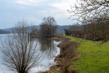 Ziyaretçiler, huzurlu bir günde Seine Nehri 'nin sakin sularında gezip yemyeşil ve büyüleyici La Roche-Guyon manzarasının tadını çıkarıyorlar..