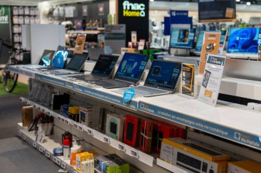 Chambourcy, France-09.03.2025 Parlak aydınlatılmış perakende satış alanı, müşterileri son teknoloji tekliflerini araştırmaya davet eden parlak dizüstü bilgisayarlar ve elektronik cihazlar sergiliyor..
