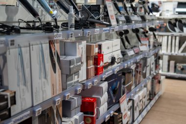 Chambourcy, France-09.03.2025 Düzenlenmiş teknoloji gereçleri dolu bir elektronik mağazasının raflarını doldurarak, en son ses ve kişisel bakım cihazlarını sergilediler..