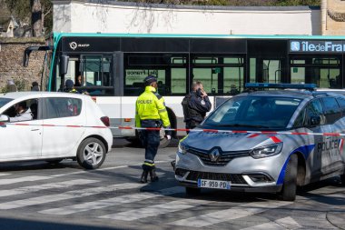 Polis memurları şehir kavşağında bir soruşturma yürütürken, izleyiciler ve toplu taşıma araçları canlı bir atmosferde geçiyor..