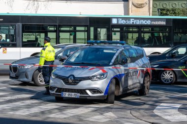 Bir polis aracı Paris kavşağında, memurların trafiği ve halkın endişelerini profesyonellik ve ihtiyatla yönetmesi ve güvenliği sağlamak için konuşlandırıldı..