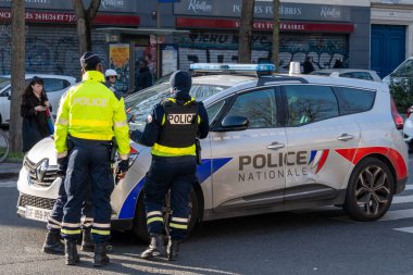 İki üniformalı memur kalabalık bir caddede bir polis aracıyla çarpışarak yayalar ve şehir yaşamının ortasında toplum güvenliğine olan bağlılıklarını gösterdiler..