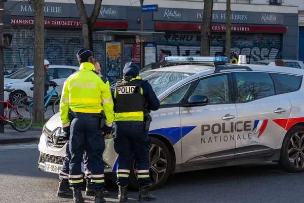 Memurlar, hareketli bir şehir caddesinde devriye arabalarıyla sohbet ediyor ve hareketli bir öğleden sonra toplum güvenliğine olan bağlılıklarını sergiliyorlar..