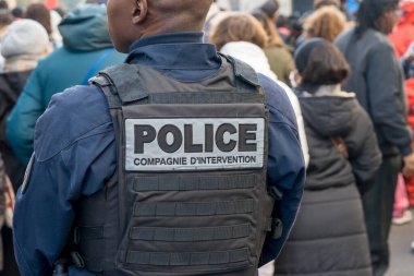 Tedbirli bir polis memurunun festival atmosferinin ortasındaki kentsel alanda güvenlik ve düzen sağlaması nedeniyle, çeşitli bir kalabalık halka açık bir etkinliğin keyfini çıkarıyor..
