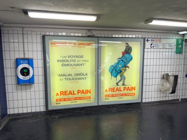 Paris, Fransa-26-02-2025 Parlak posterleri, gösterişli bir metro istasyonunda mizah ve cazibe yoluyla duygusal bir yolculuk sergileyen, ışıldayan eleştiriler ve göz alıcı sanatla banliyö halkını cezbediyor..