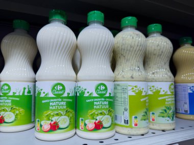 Paris, Fransa-02-03-2025 çeşitli salata soslarından oluşan parlak yeşil şişeler market raflarında müşterileri davet eden bir dizi lezzet ve canlı ambalaj sergiliyor..