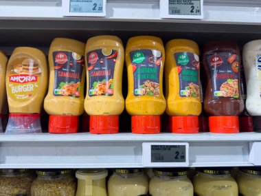 Paris, Fransa, Fransa-02-03-2025 Rafları çeşitli gurme soslarla kaplanmış, öğle vakti alışveriş saatlerinde hareketli bir süpermarkette eşsiz lezzetler ve parlak etiketler içeren gözlere takılıyor.