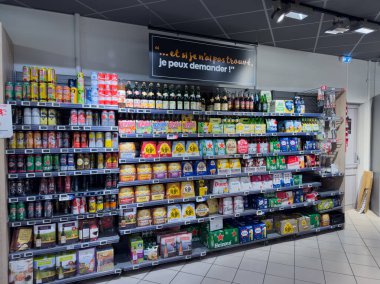 Paris, Fransa-02-03-2025 Parlak ışıklı market koridorları çeşitli ürünler sergiliyor, müşterileri aperatiflerden içeceklere kadar değişen seçenekleri keşfetmeye davet ediyor, hepsi düzenli olarak düzenlenmiş..