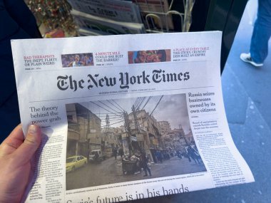 Paris, Fransa-28-02-2025 Yoldan geçen biri, kentin canlı enerjisiyle çevrelenmiş bir gazeteyi kavrayıp, canlı bir şehir ortamında günlük haberlerin manşetlerini ve yansımalarını sergiliyor.