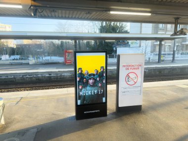 Paris, Fransa-28-02-2025. Parlak ışıklı reklam tren istasyonunda duruyor. Trenler gelip giderken bekleyen yolcuların dikkatlerini çekiyor..
