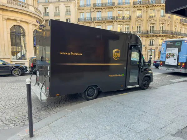 Paris, Fransa-05-03-2025 Bir dağıtım aracı, tarihi mimari ve öğleden sonra ışığında hareketli bir dizi aktiviteyle dolu canlı bir şehirde ustalıkla manevra yapıyor..