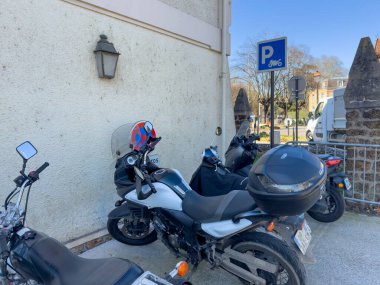Villennes-sur-Seine, Fransa-06-03-2025 Bir motosiklet koleksiyonu tarihi bir yerin yakınındaki büyüleyici bir sokakta dinleniyor, keyifli bir bahar akşamüstü güneşinin altında güneşleniyor.
