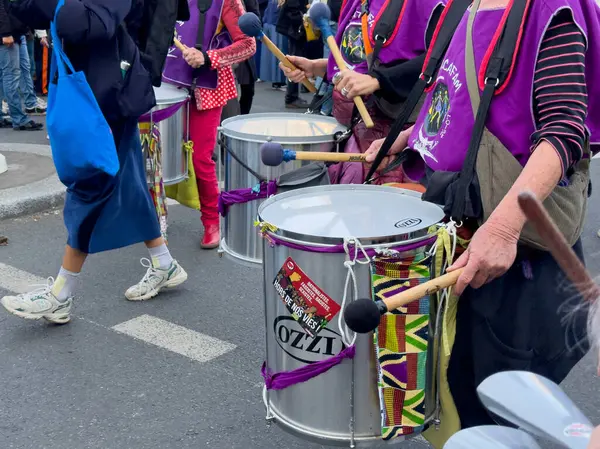Paris, Fransa-08-03-2025 Renkli davulcular canlı bir sokak festivali sırasında hareketli bir atmosfer yarattılar. Kutlama için birlikte yürürken ritim ve birlik gösterisi yaptılar..