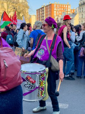 Paris, Fransa-08-03-2025 Hareketli şehir meydanında, coşkulu bir davulcunun ritmi canlı tutmasıyla, tutkulu sesler toplumsal amaçlar için birleşirken coşkulu bir toplantı patlak verdi..