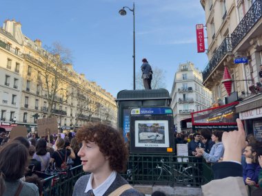 Paris, Fransa-08-03-2025 Kalabalıklar Paris 'in hareketli caddelerini dolduruyor, tek bir kişi büfenin tepesinde durup, birlik ve eylemi desteklemek için tabelalarla bir araya geliyorlar..