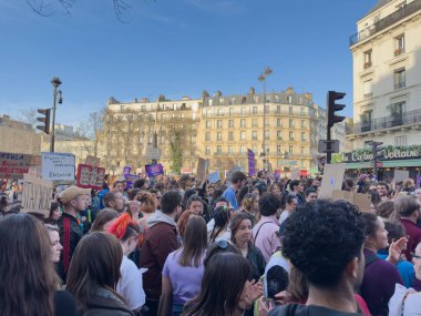 Paris, Fransa-08-03-2025 Canlı şehir meydanında binlerce insan renkli işaretlerle toplanıyor, tutkuyla birleşip değişim çağrısında bulunuyor..