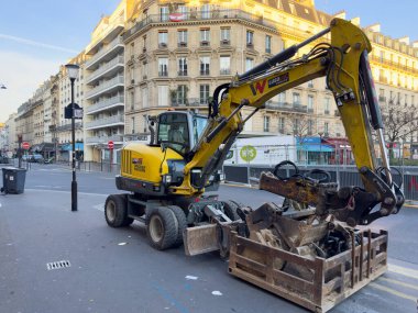 Paris, Fransa-08-03-2025 Ağır makineler Paris 'in canlı bir caddesinde özenle çalışıyor, yayalar günlerini geçirirken inşaatı şehrin cazibesiyle harmanlıyor..