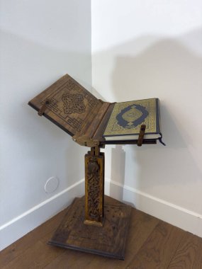 Villennes-sur-Seine, Fransa-12-03-2025 Büyüleyici bir ahşap tezgah zarif desenler ve zengin renkler sergileyen süslü bir kitap tutuyor. Güneş ışığı nazikçe filtreler, işçiliği vurgular.