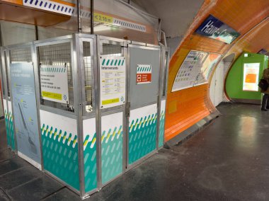 Paris, Fransa-12-03-2025 aydınlık yeraltı istasyonu yeni güncellenmiş ulaşım işaretleri ve interaktif büfeler sergiliyor, akşam yolculuklarına çıkan yolcuların enerjilerini yakalıyor..