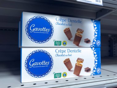 Villennes-sur-Seine, Fransa-15.03.2025 Rafları güzel paketlenmiş çikolata soslu gofretlerle süslenmiştir. Müşterileri lezzetli atıştırmalıkların tadını çıkarmaya davet eder..