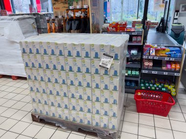 Paris, Fransa-16-03-2025 Canlı bir şişe içki yığını kalabalık bir markette gözüme takıldı. Müşteriler atıştırmalık ve temel ihtiyaçlarla dolu koridorları inceliyorlar..