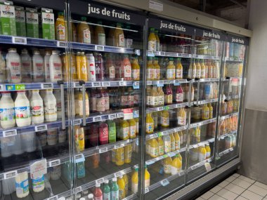 Paris, Fransa-16-03-2025 Canlı meyve suyu sıraları süpermarket koridorlarında alışverişçiler için seçenekleri ön plana çıkarıyor, yaz gününün sıcak güneşinin tadını çıkarıyorlar..