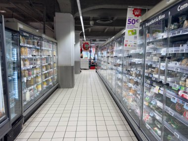 Paris, Fransa-16-03-2025 parlak ışıklı market koridoru sayısız donmuş gıda seçeneği sunarak, müşterileri çeşitli yemek seçeneklerini keşfetmeye davet ediyor. Ortam hoş ve düzenli..