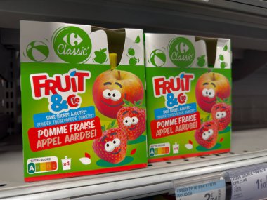 Villennes-sur-Seine, Fransa-01.03.2025 Çizgi film karakterlerinin yer aldığı renkli abur cubur kutuları bir market rafında dikkatleri çekerek, çocukları ve yetişkinleri bu tatlı, sağlıklı