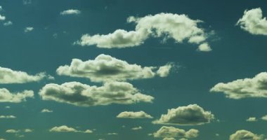 Mavi gökyüzünün zamanı, bir sürü kabarık kümülüs bulutu dönüşüyor ve hareket ediyor.