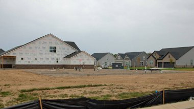 McCordsville, Indiana, USA -September 22 2024: A home building boom leads to new home construction in the suburbs in the midwest. Here we have a foundation under construction on a site with utilities and piles of dirt and grave clipart