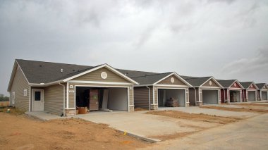 Greenfield, Indiana, ABD - 22 Eylül 2024: Bir ev inşaatı patlaması orta batıdaki banliyölerde yeni bir ev inşaatına yol açtı. Burada inşaat halindeki yeni bir apartman dairemiz var. Her birinde garaj ve küçük evler var.