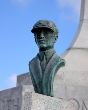 Bakır Orville Wright, Wright Kardeşler Ulusal Anıtı 'nda mavi gökyüzü ve arkasında kulenin bir kısmının bulunduğu baskını gerçekleştirdi..