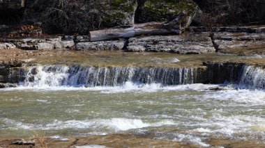 Kışın küçük bir nehirde şelale şelalesi.