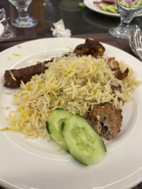 Restoranda ızgara Et Şişi ve Salatalık Dilimleri ile Hint Biryani Pirinci