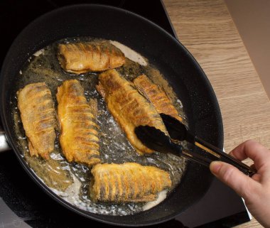 Balık, ayçiçeği yağında kızartma tavasında kızarır.