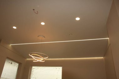 Kablolu şerit, modern kolye ışığı ve sönük ışıkları birleştiren esnek tavan. Tavan pürüzsüz ve hafiftir, baştaki şeridin kenarlardan geçtiği yerin biraz altında bulunan dikdörtgen bir bölüm vardır.. 