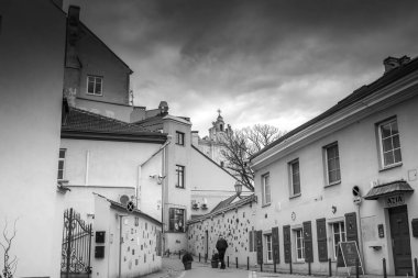 Literatu Caddesi (Literatu Gatve) olarak bilinen Vilnius 'ta dar bir viraj caddesini gösteren siyah ve beyaz bir fotoğraf. Caddedeki evlerin duvarları Litvanyalı yazarlara adanmış birçok küçük fayans, plaket ve sanat eserleriyle süslenmiş.