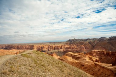 Güzel manzara, turuncu kanyon dağları ve bulutlu gökyüzü
