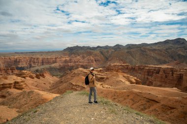 Sırt çantalı kadın turist güzel turuncu kanyon dağlarına, dikiz manzarasına bakıyor.