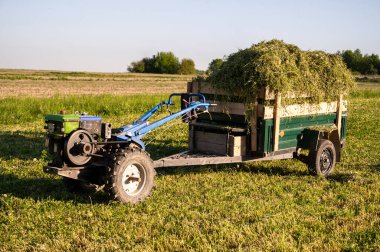 Güneşli bir yaz gününde tarlada samanlı mini traktör..
