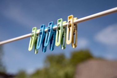 İlkbaharda mavi gökyüzüne karşı çamaşır ipinde mandallar.