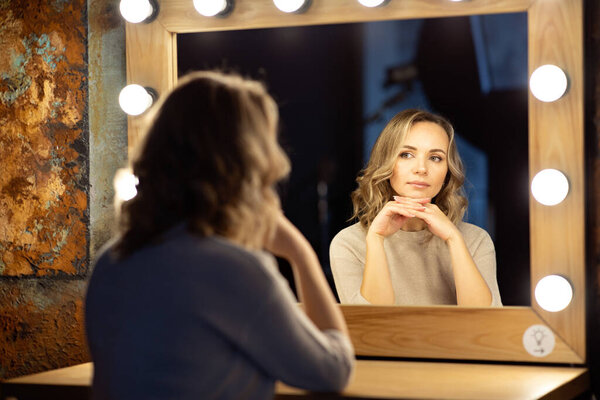Портрет молодой женщины, смотрящей на свое отражение в зеркале.