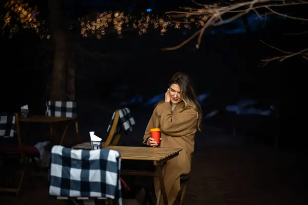 Akşamları bir kafedeki masada elinde bir bardak kahveyle yalnız güzel bir kız.