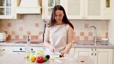 Genç bir kadın mutfakta yemek pişiriyor.