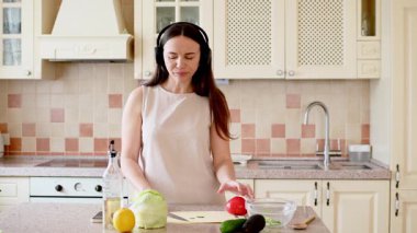 Mutfakta taze sebzeli ve meyveli bir kadın.