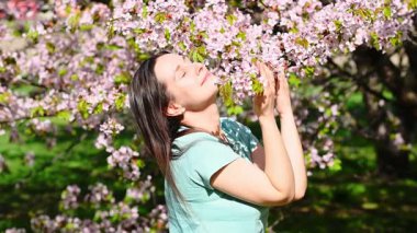 Çiçek açan bahçede güzel genç bir kadın..
