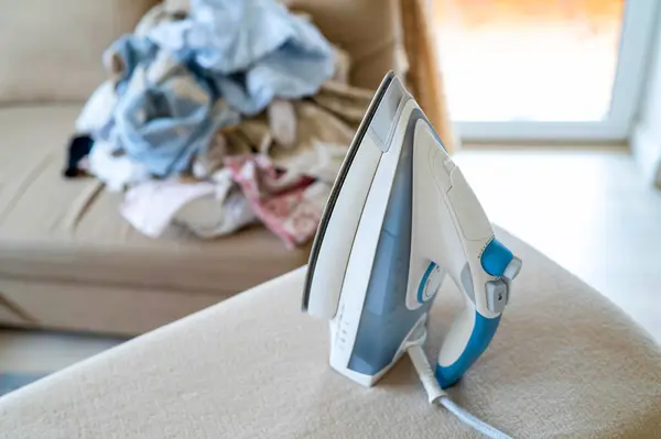 Güvertede demir, kanepede buruşuk giysiler, rahat iç mekanda sıcak gün ışığı.