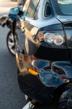 Çarpışmadan sonra görünen deformasyon, çizikler ve boya hasarı olan ezilmiş otomotiv panelinin detaylı görüntüsü.